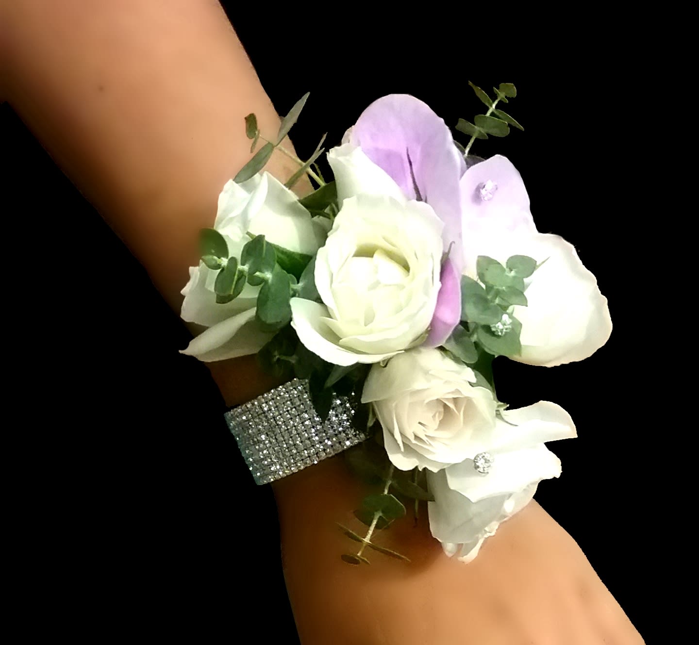 White rose wrist corsage with light lavender accents on a rhinestone band.