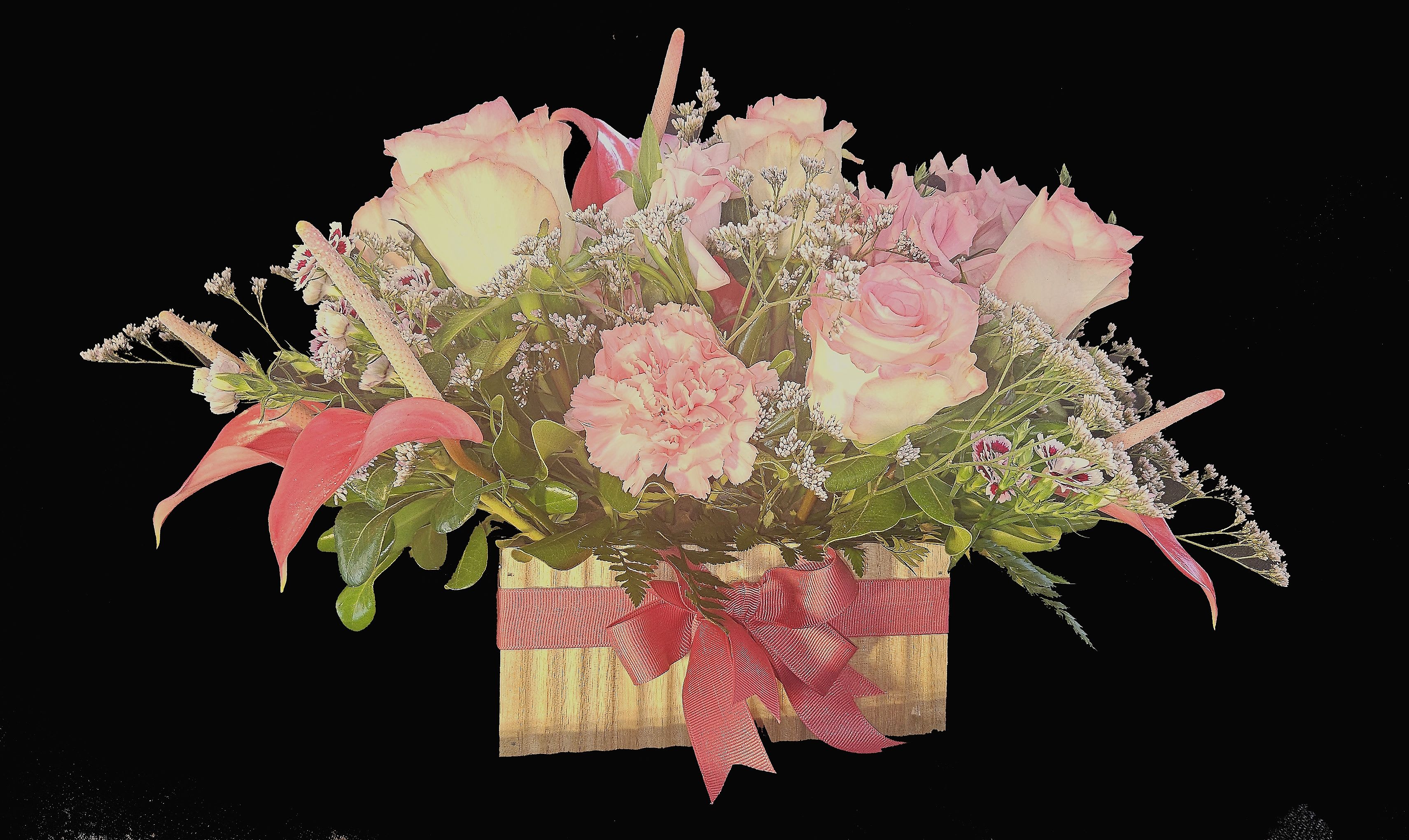 Low wooden box arrangement with pink roses, carnations, and mini calla lilies accented with small white blooms.