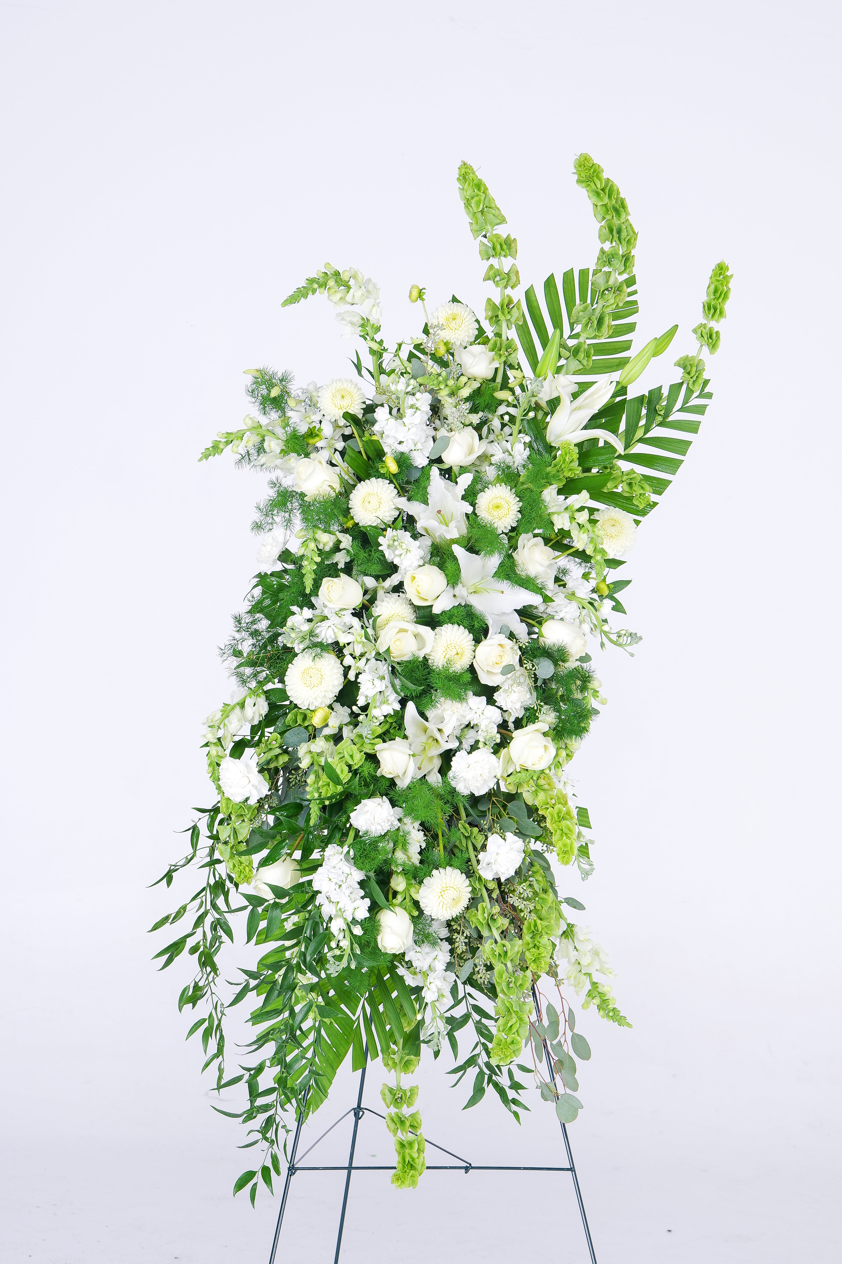 Tall white floral standing spray with lilies and roses