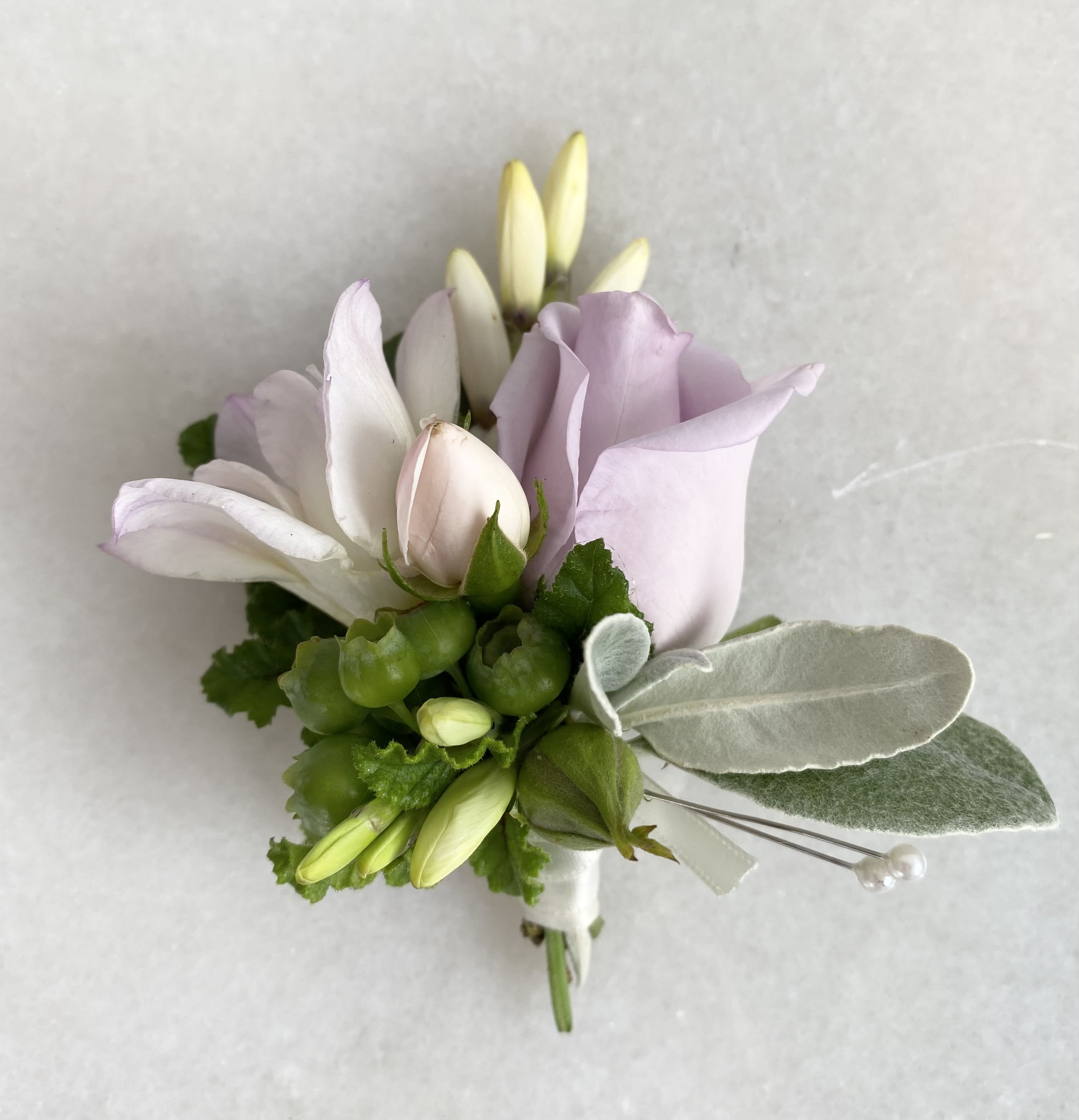 Small boutonniere with pale lavender and white flowers