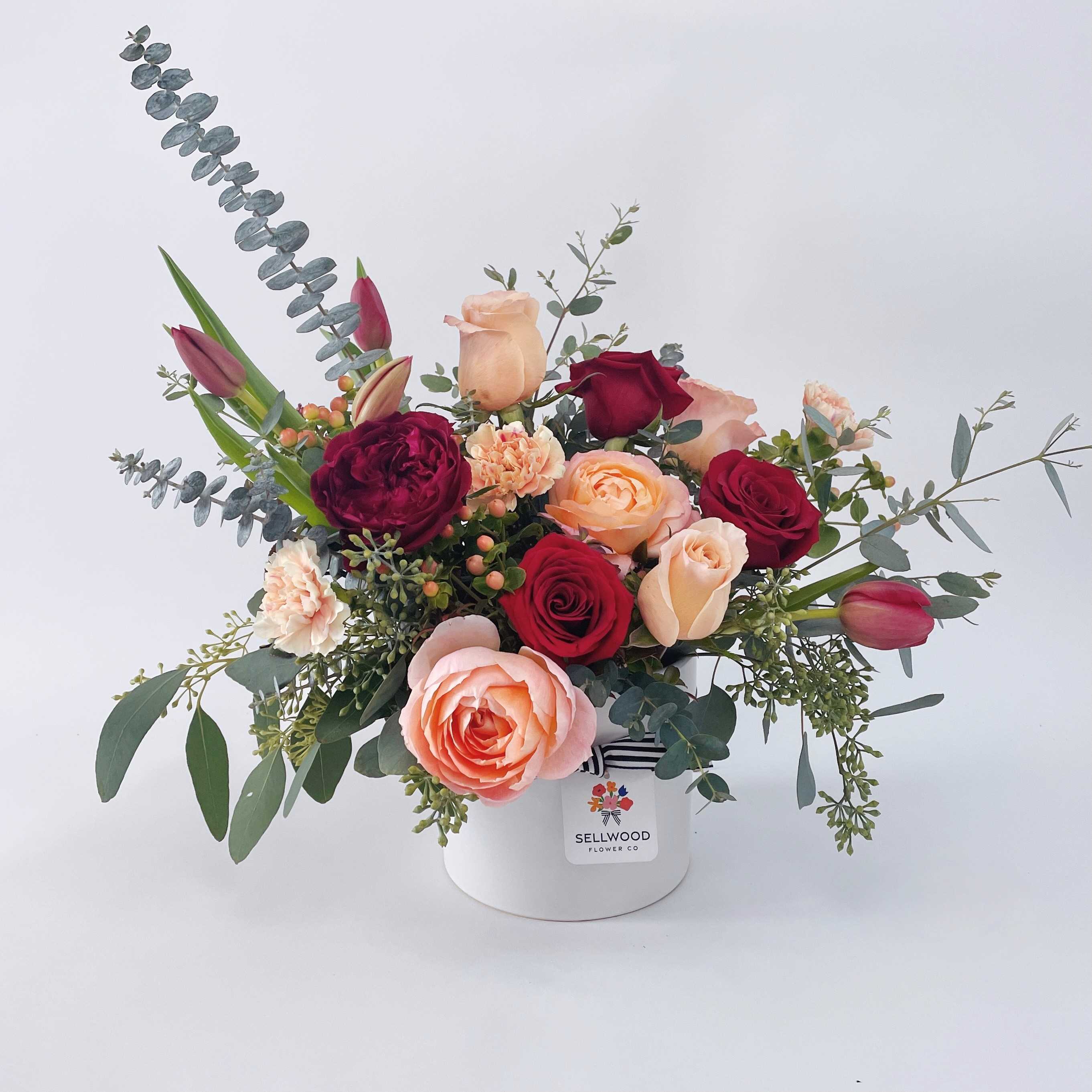 Mixed rose bouquet in a white hat box with eucalyptus accents
