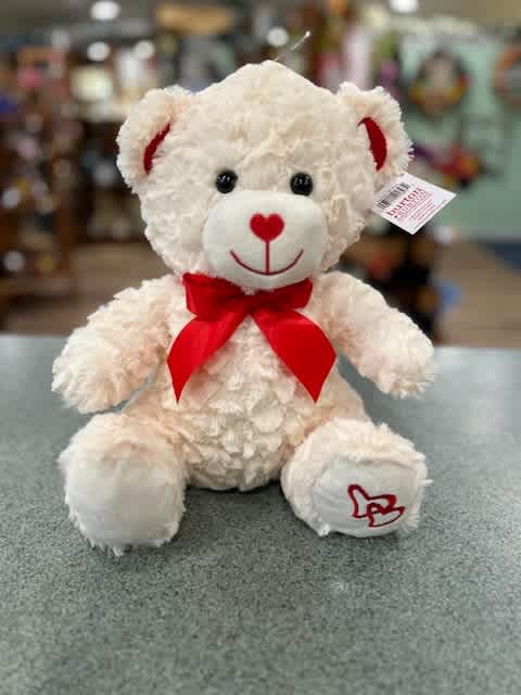 White teddy bear with a red bow and heart details
