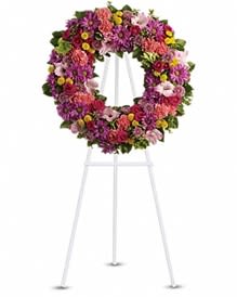 Colorful floral wreath on a white easel stand