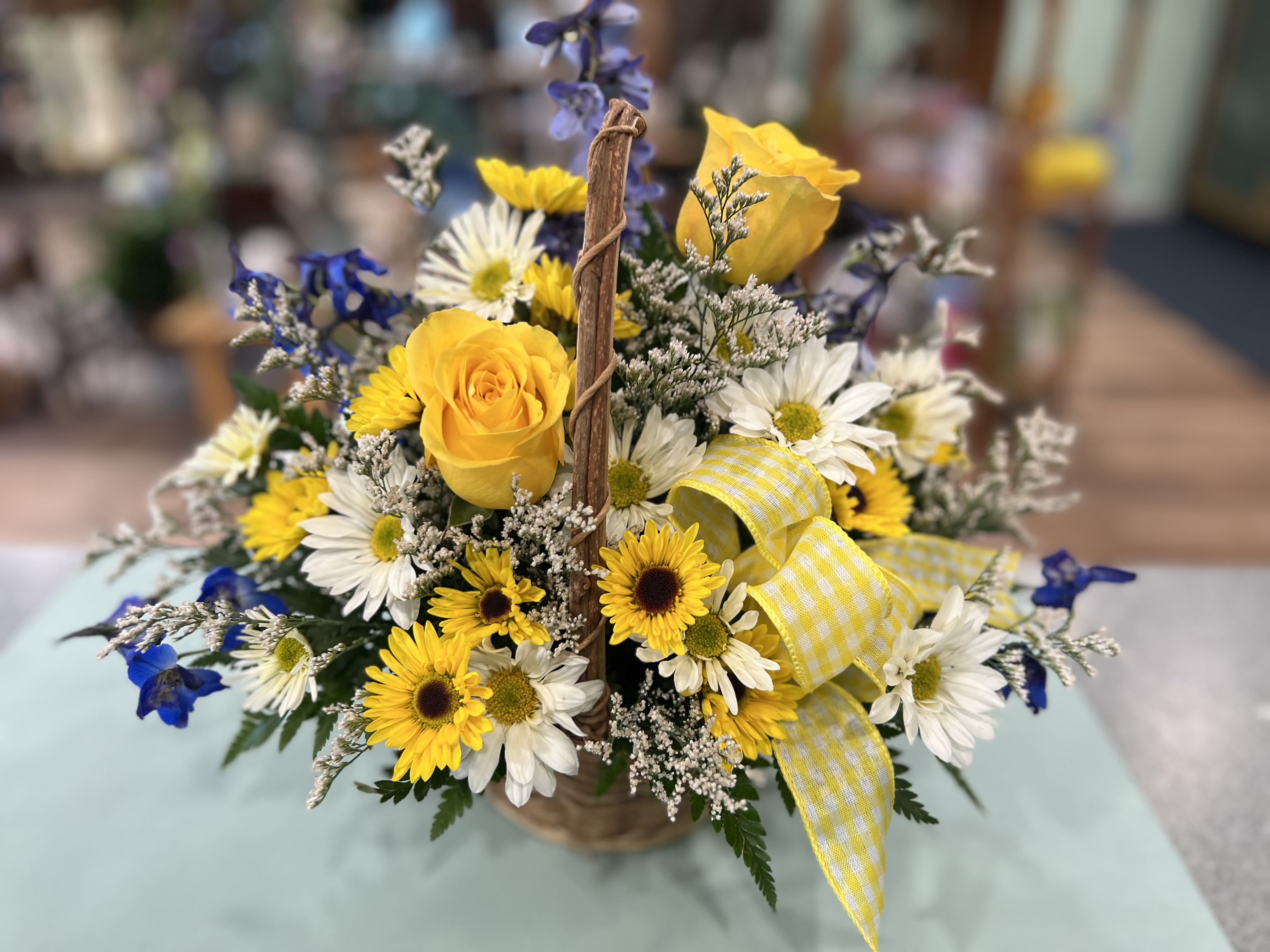 Thinking of you Basket (TOYB) - A nice way to tell someone you are thinking of them. A small basket filled with deliphium, yellow roses and oither assorted flowers.