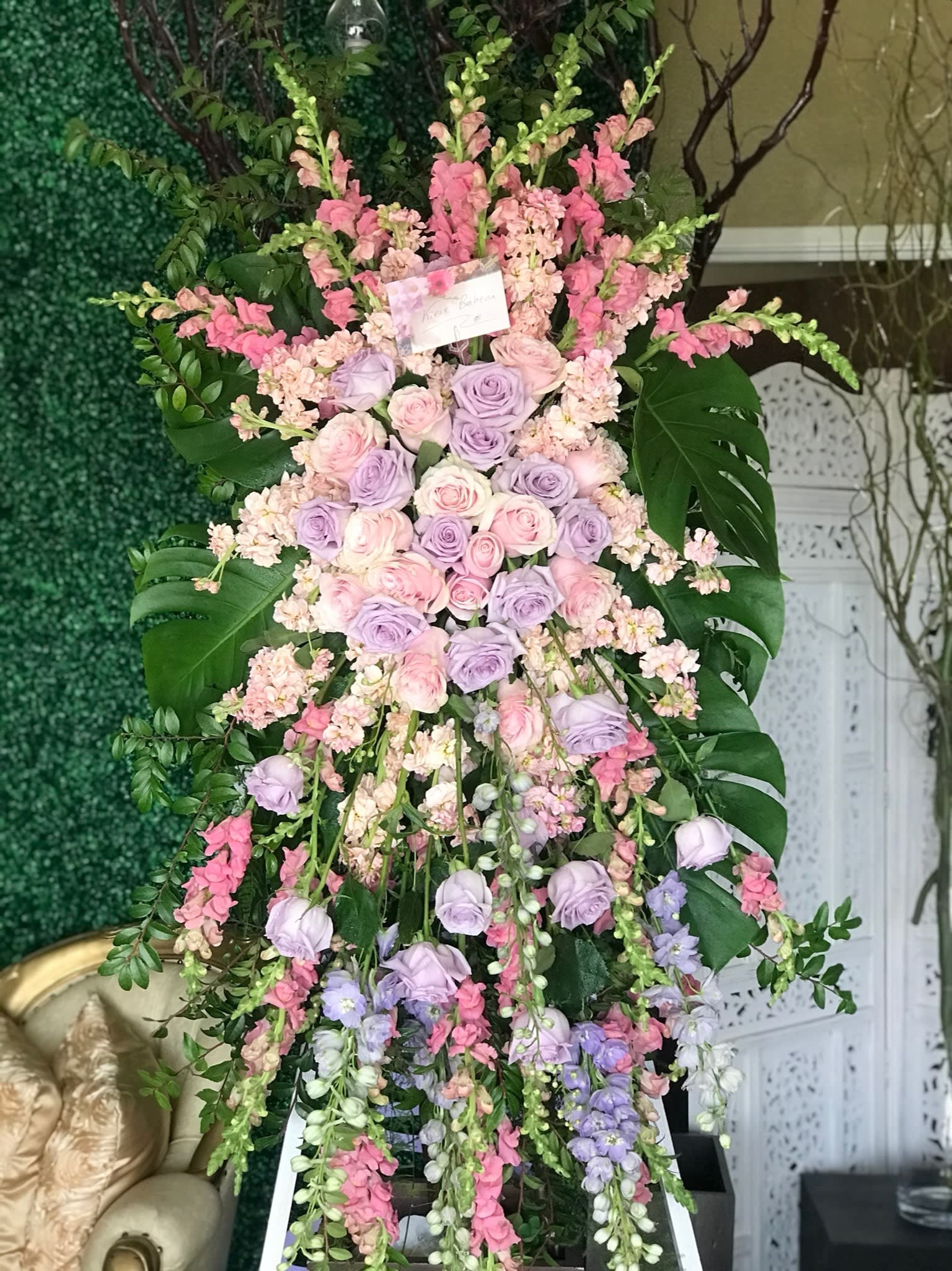 Tall pastel floral standing arrangement with roses and cascading blooms