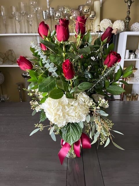 The Perfect Dozen - A dozen red roses are always perfect, always savored. Dozen of red roses, greenery and white hydrangeas in clear vase .