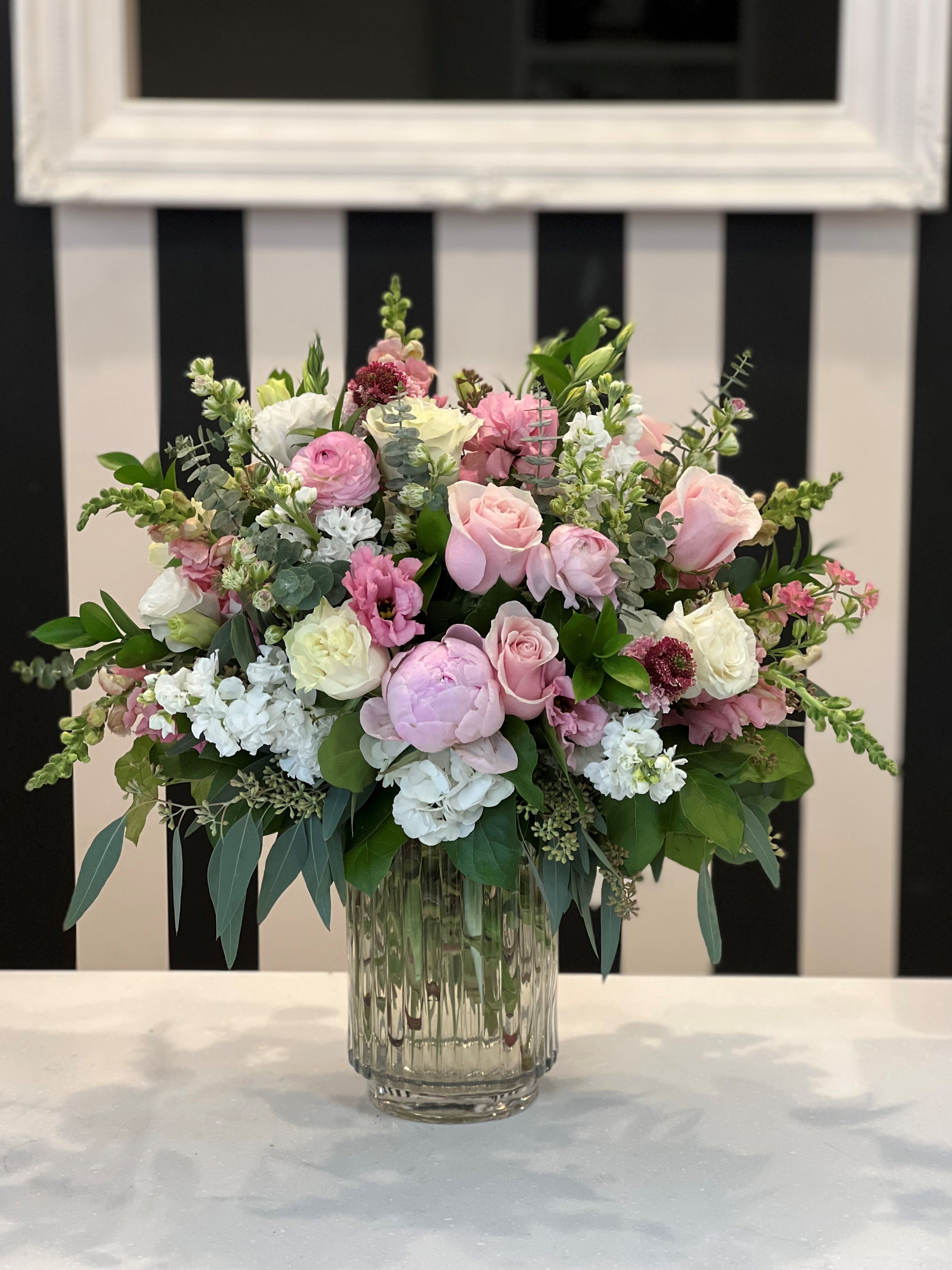 Pink and white floral arrangement in a clear glass vase