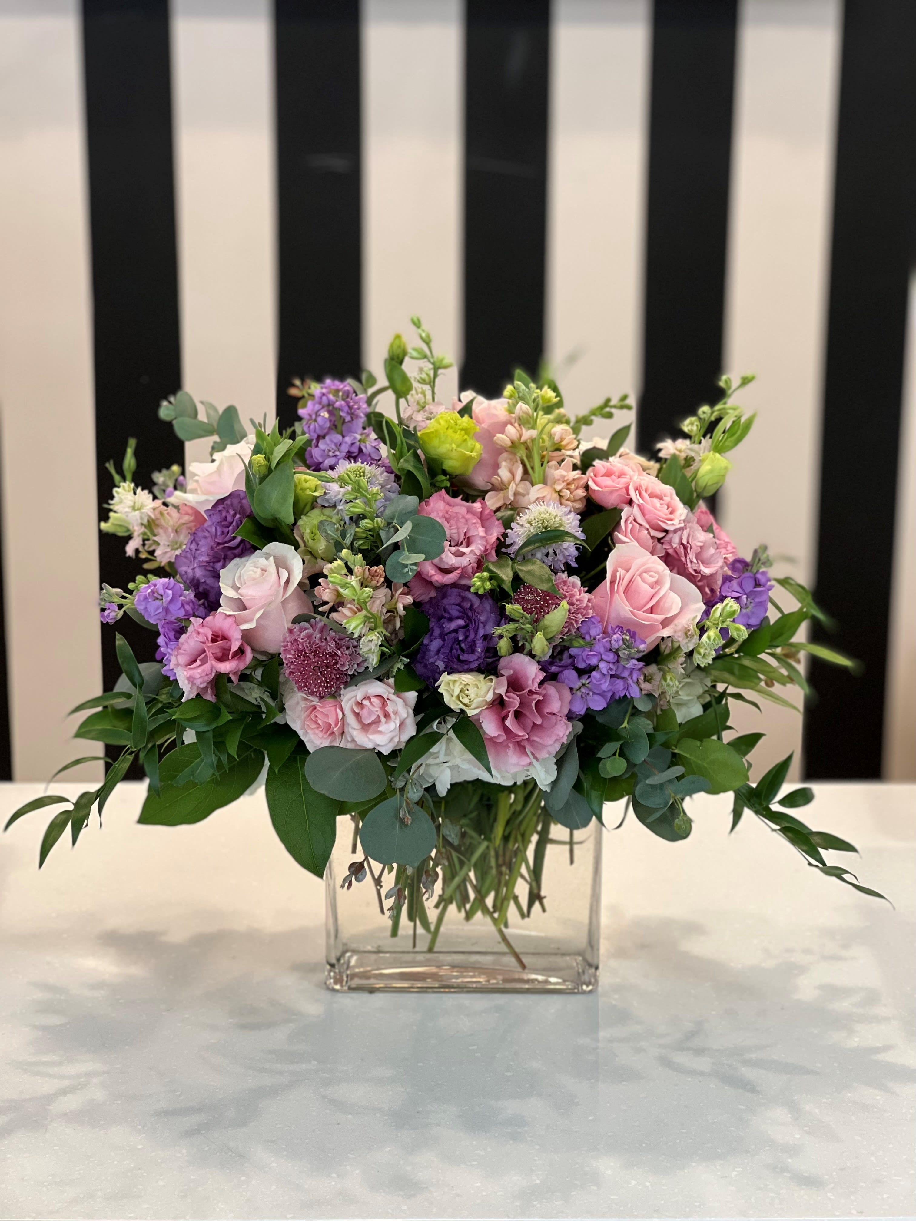 Pink and purple mixed bouquet in a clear glass vase