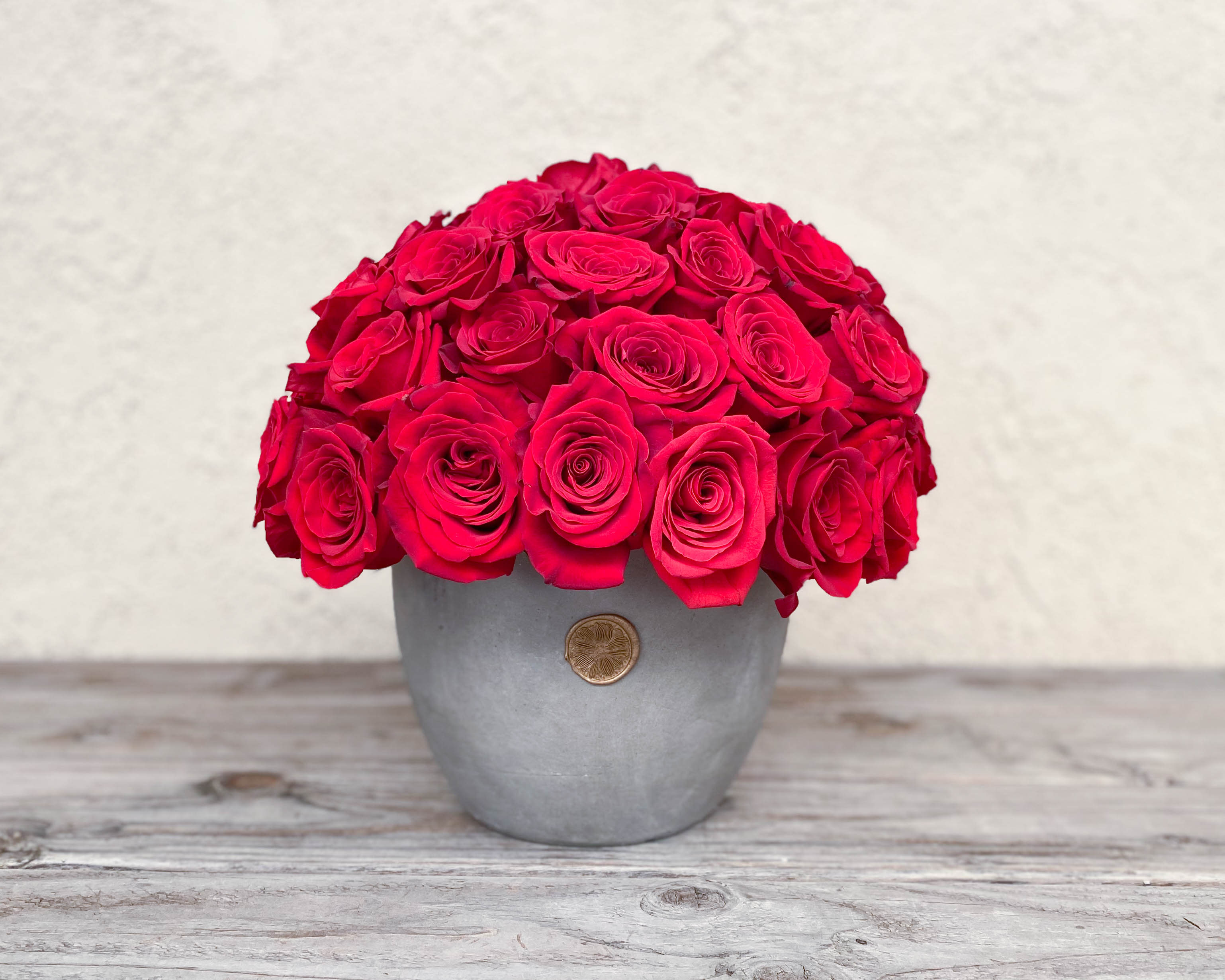 Round bouquet of bright pink roses in a gray vase