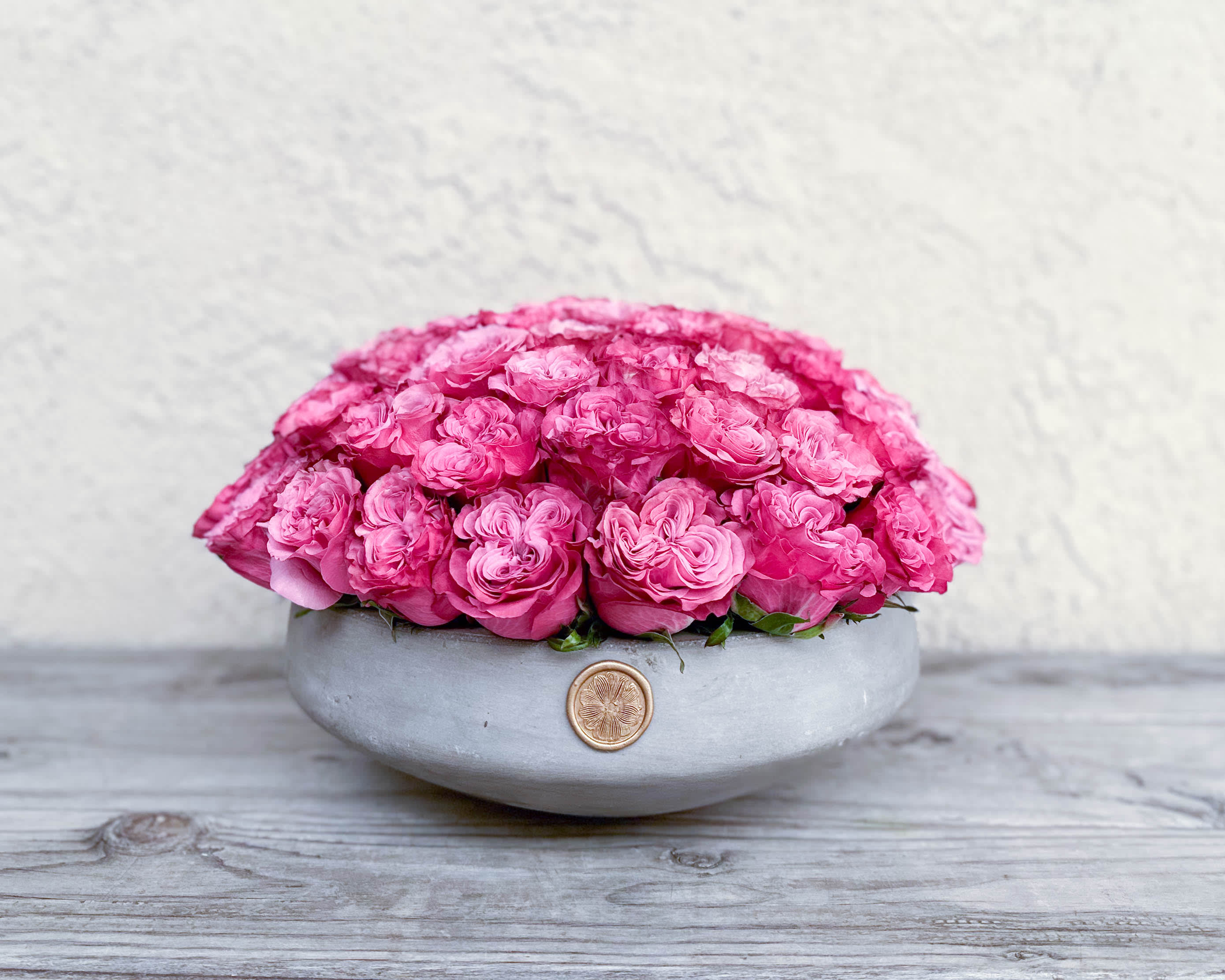 Pink roses arranged in a low gray bowl vase