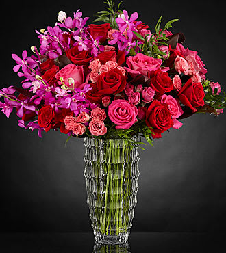 Bouquet of red and pink roses in a clear glass vase