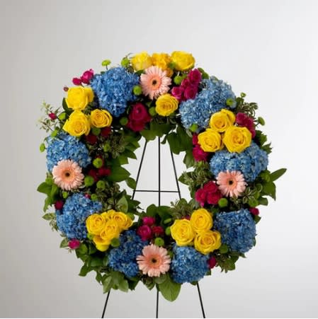 Vivid Spring by BloomNation™  - This colorful and bright wreath spray is representative of a life lived to its fullest. Colors and Flowers may change based off of season and availability. 