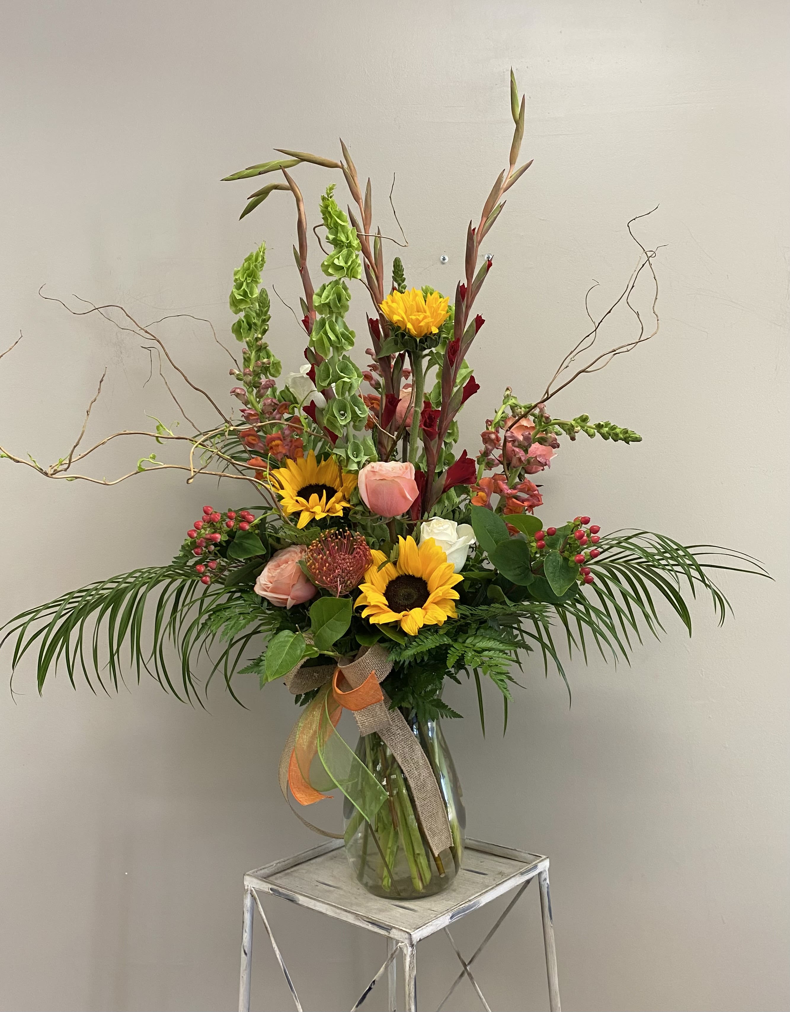 Desert Mirage - A mix of autumn inspired colors from the desert perfect for any day. Filled with sunflowers, gladiolas, peach roses and snap dragons. 