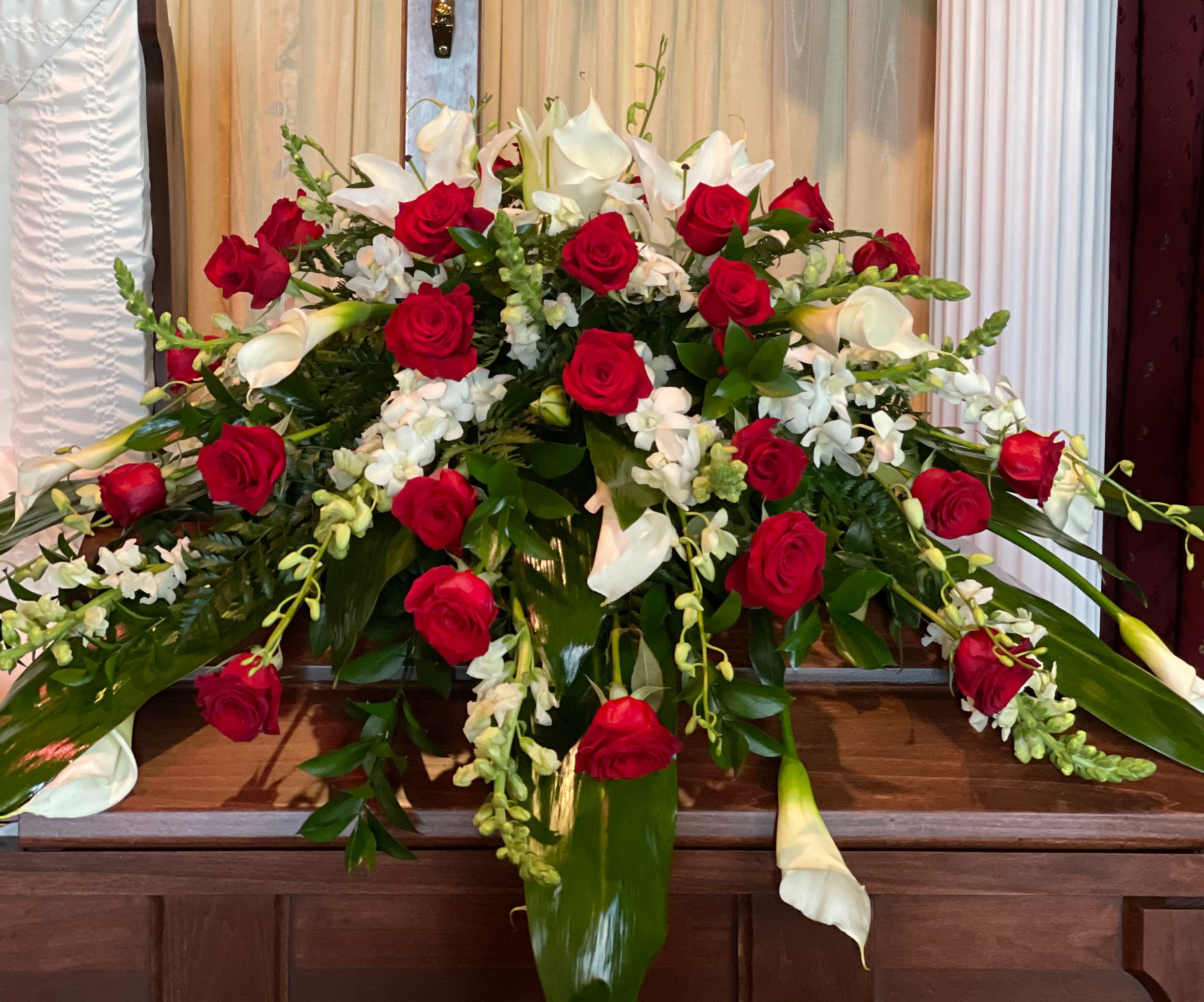 Large floral arrangement with red roses and white calla lilies