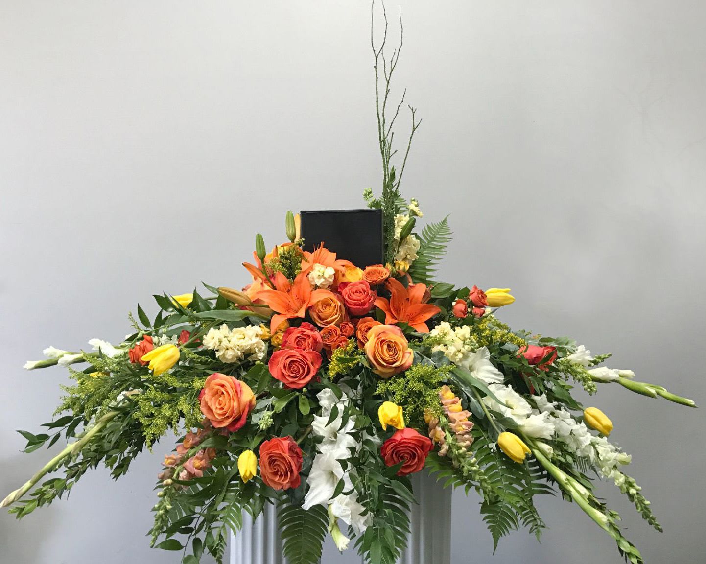Large orange and yellow floral spray with roses and lilies