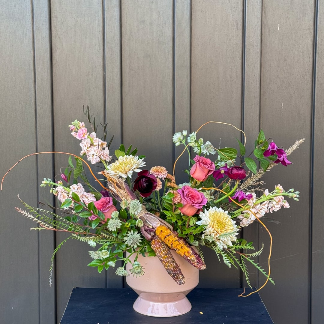 Mixed bouquet in a blush pedestal vase with pink and white blooms