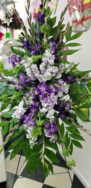 Tall purple and white floral standing spray on an easel
