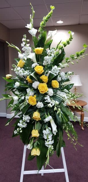Tall yellow and white floral standing spray on an easel