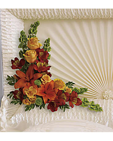 Casket spray with orange lilies, red flowers, and yellow roses