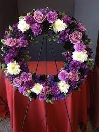 Purple and white floral wreath on a stand