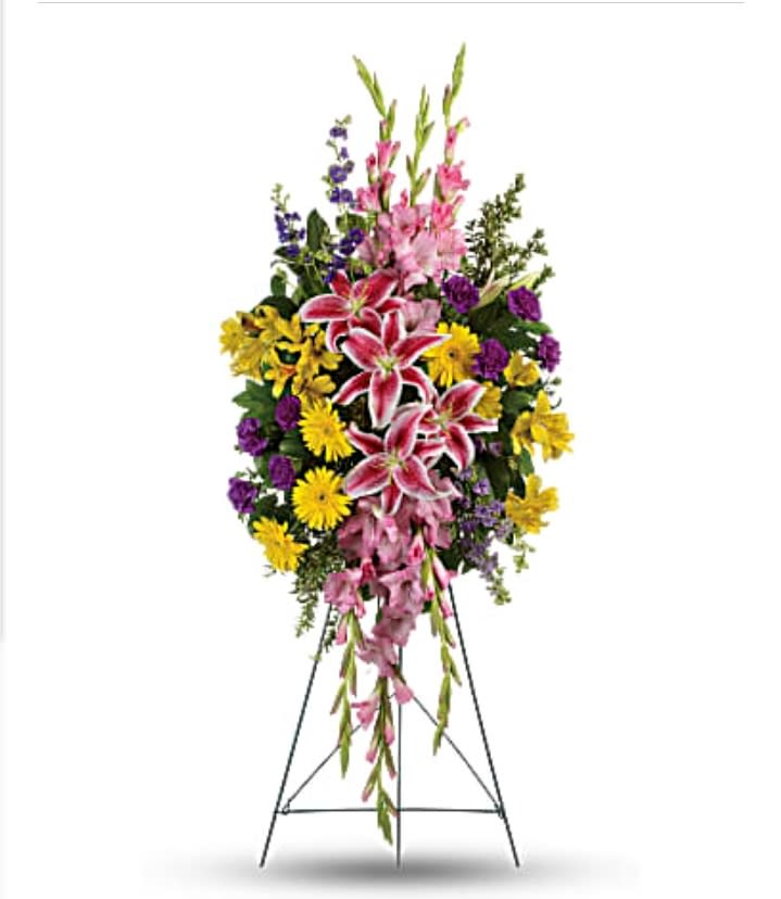 Standing floral spray with pink lilies, yellow daisies, and purple flowers