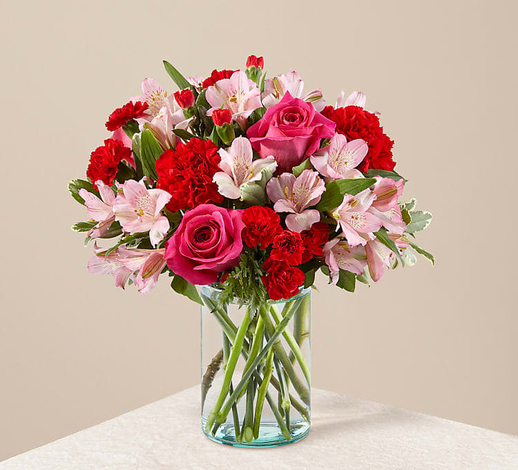 Pink roses and red carnations in a clear glass vase