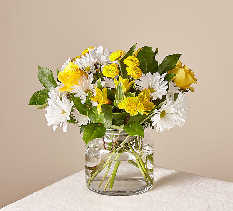 Yellow and white mixed bouquet in a clear glass vase