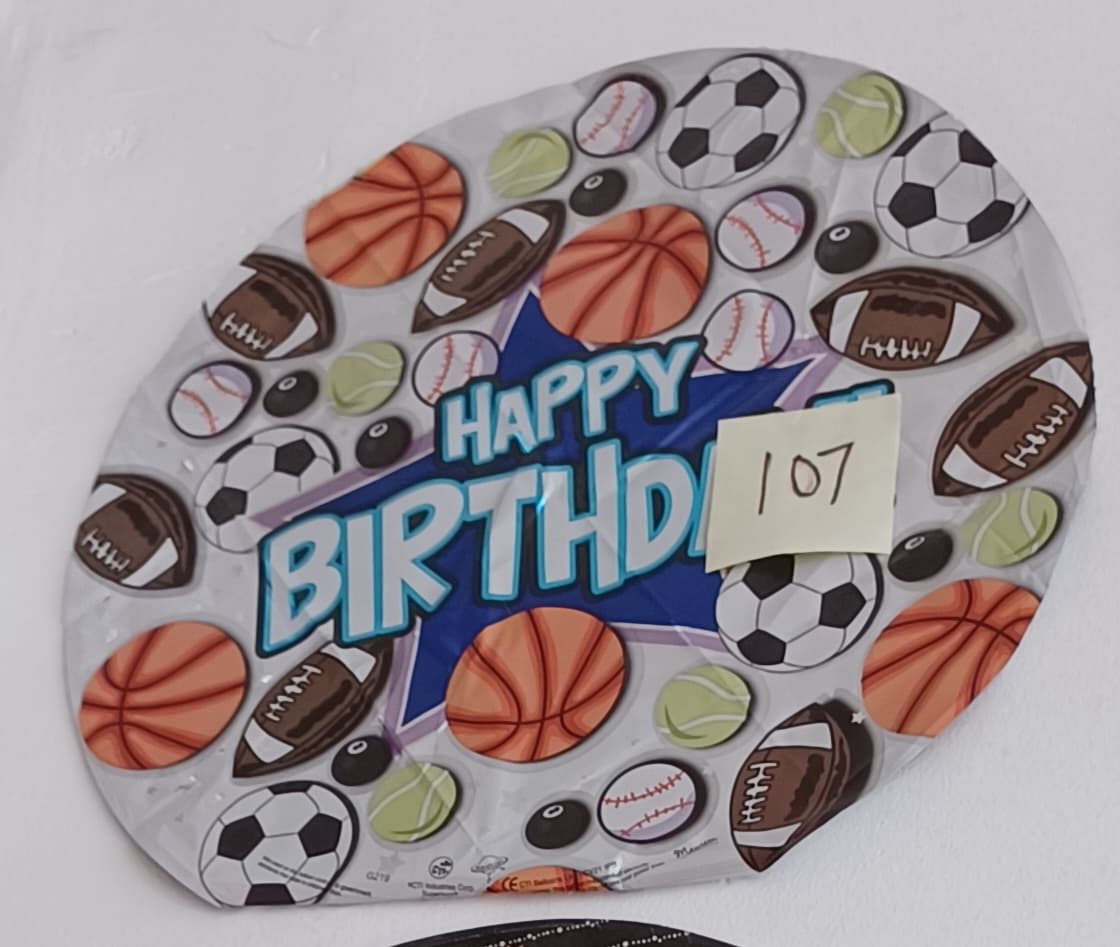 Round birthday balloon with sports balls and "Happy Birthday" text