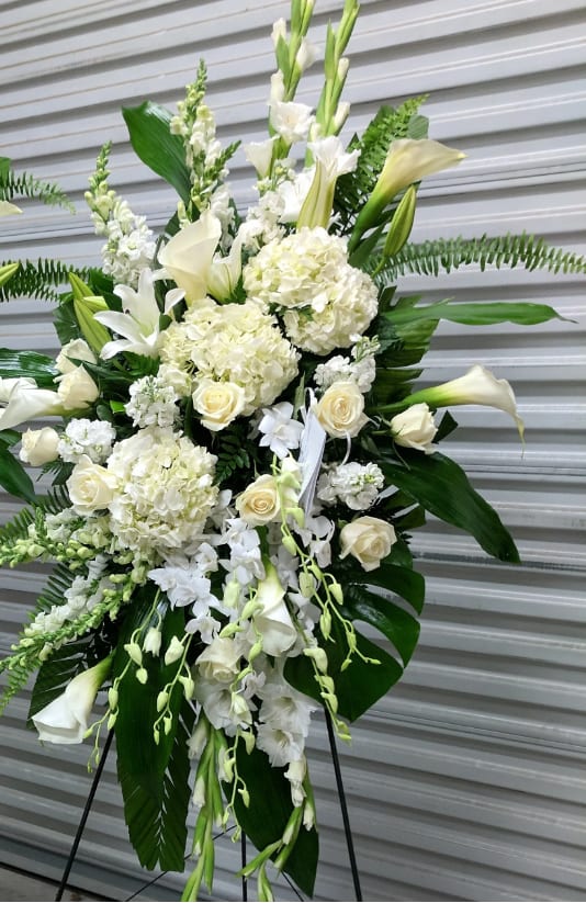 White floral standing spray with roses, lilies, and calla lilies