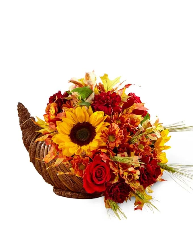 Autumn flower arrangement in a woven cornucopia basket with sunflowers and roses
