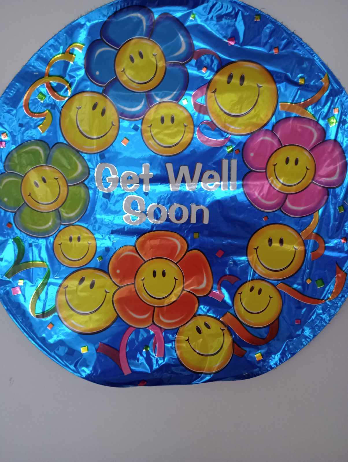 Round blue balloon with smiley-face flowers and "Get Well Soon" text