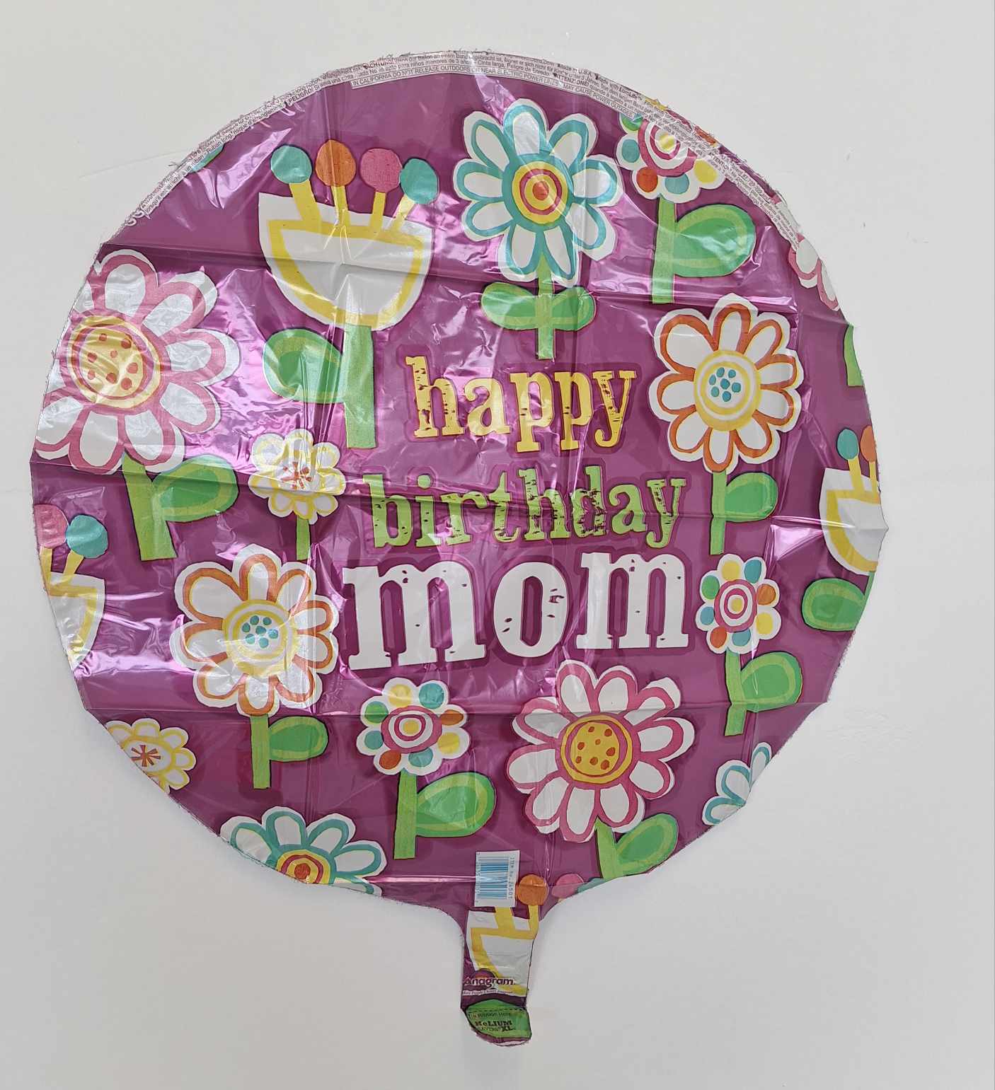 Round purple birthday balloon reading "happy birthday mom" with flower graphics