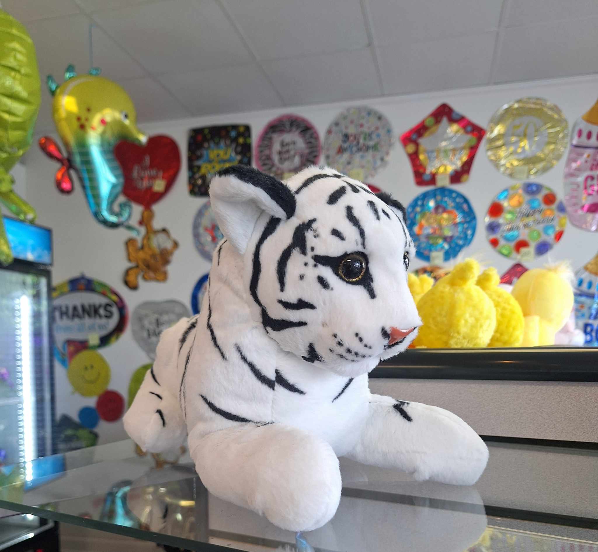 White plush tiger toy with black stripes on a counter
