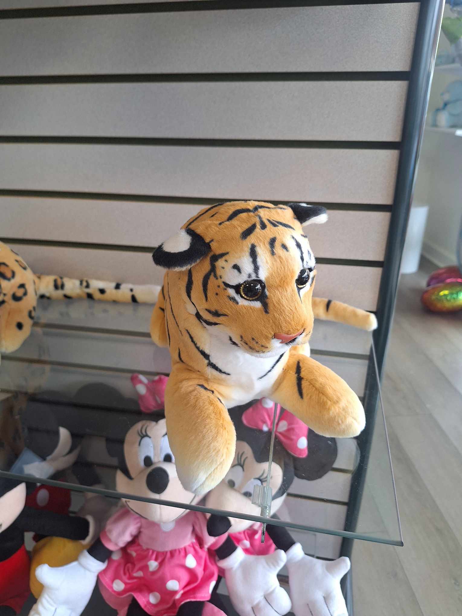 Plush tiger toy on a glass shelf