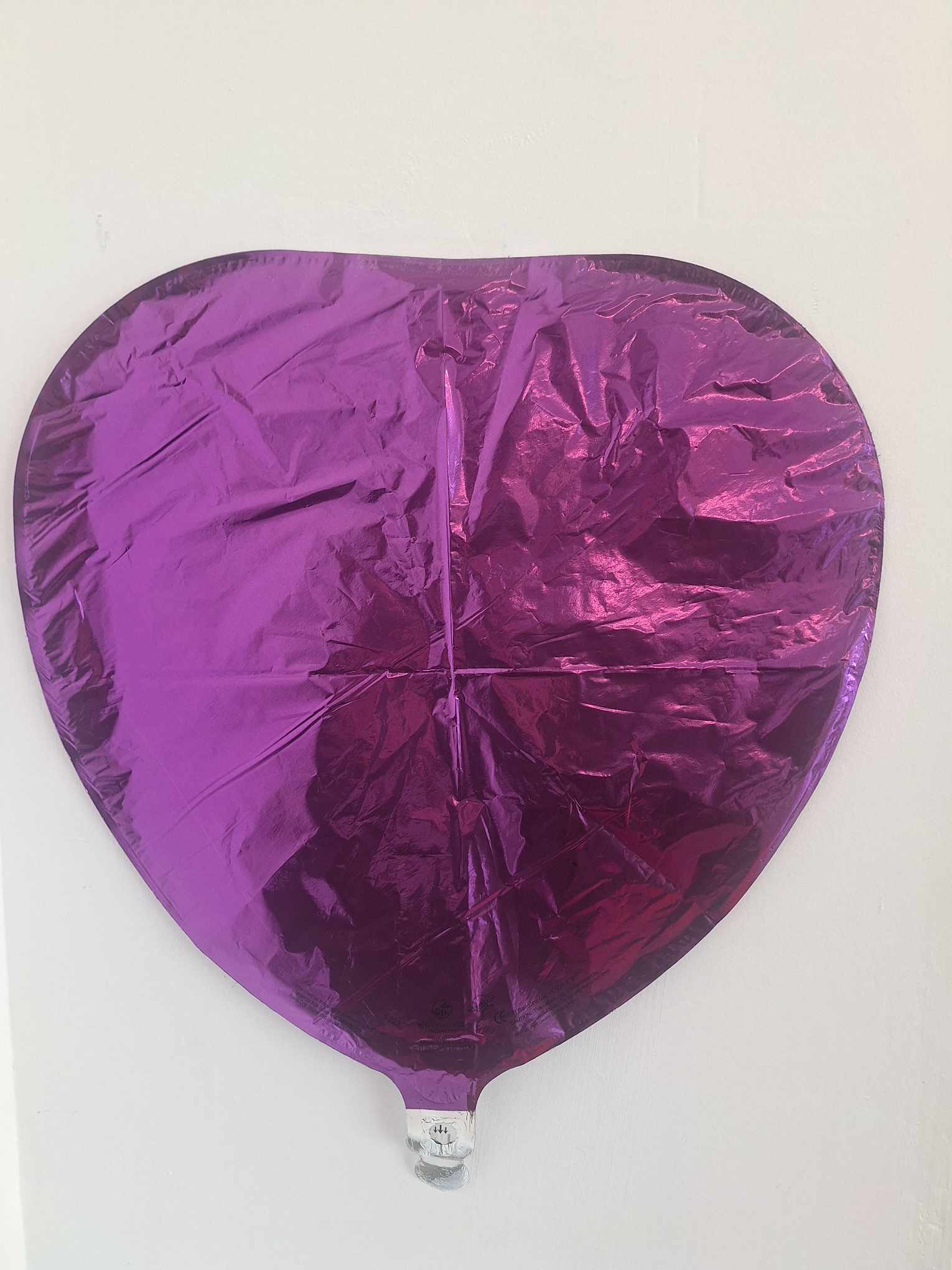 Purple heart-shaped foil balloon on a white background