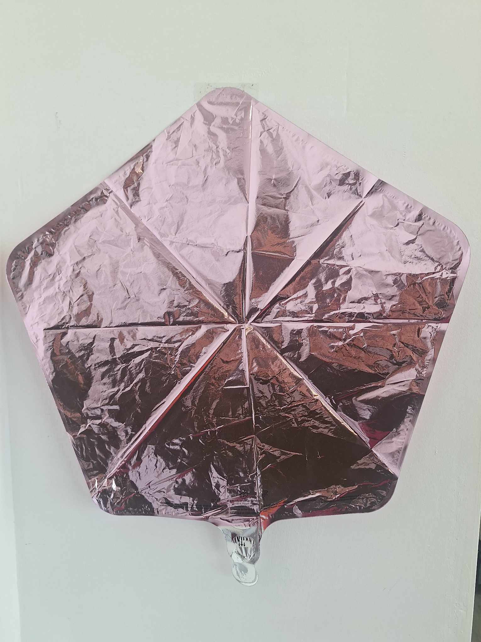 Pink metallic star-shaped foil balloon on a plain background
