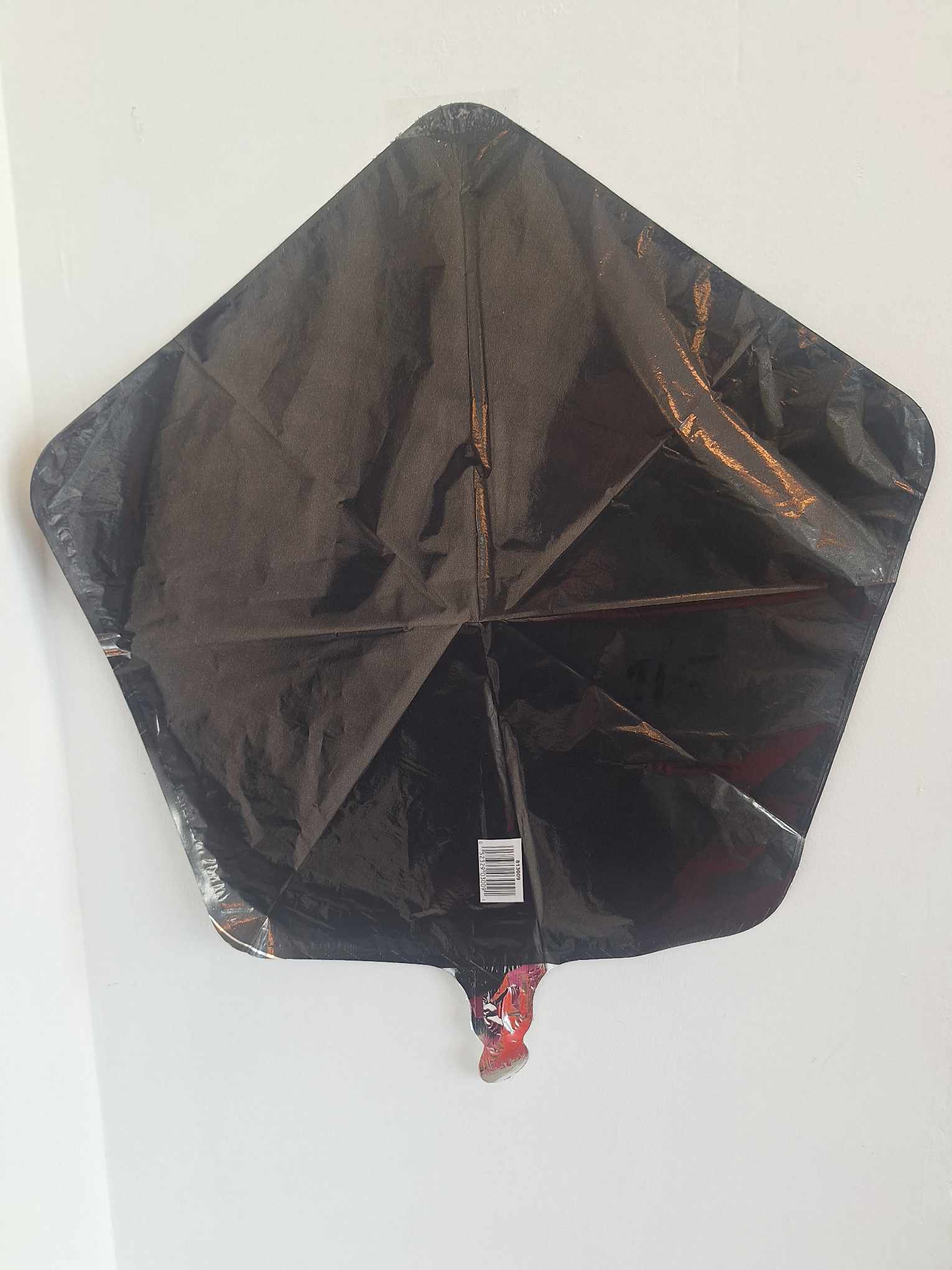 Black star-shaped foil balloon against a white background