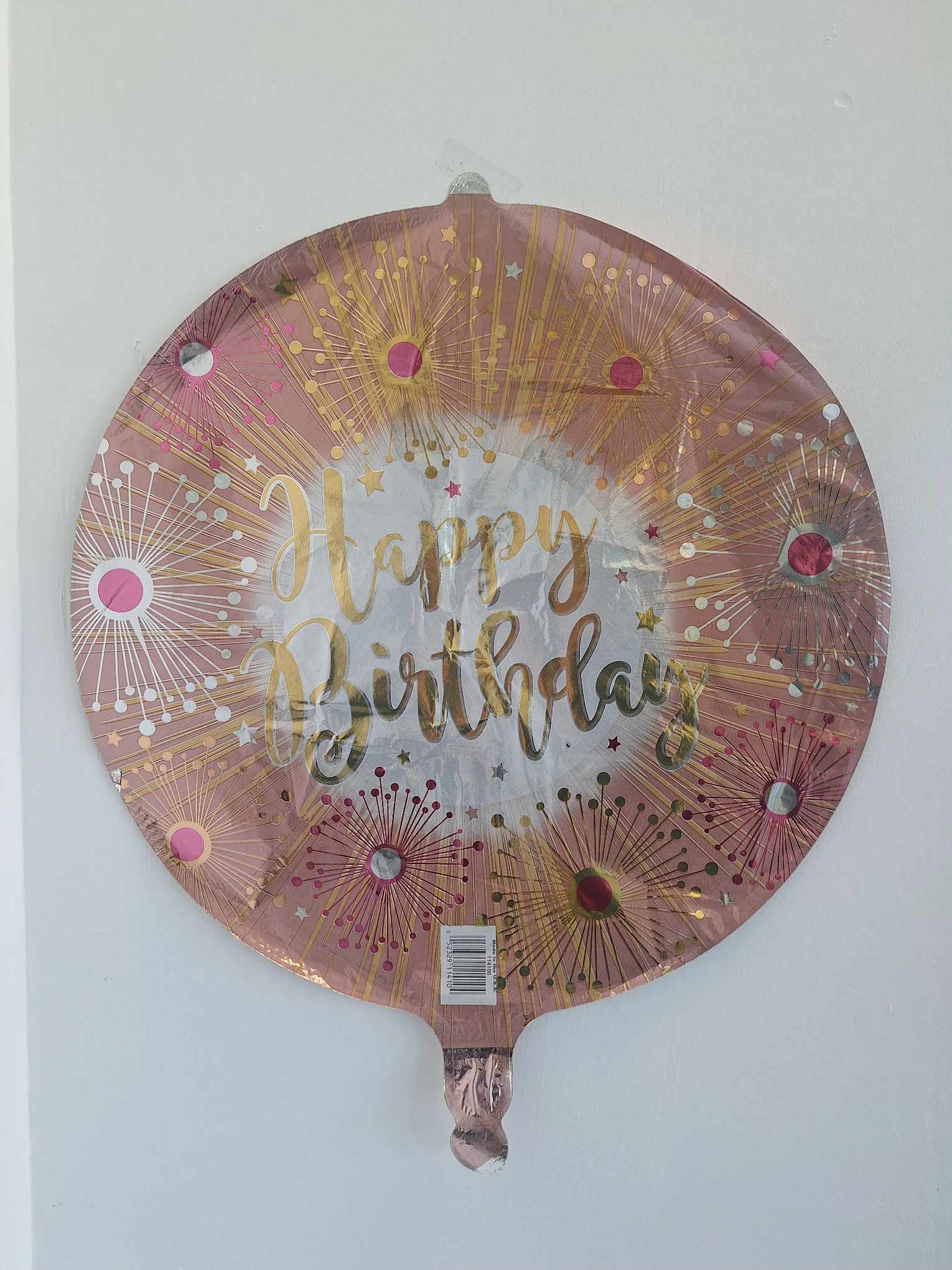 Round pink foil balloon with "Happy Birthday" text