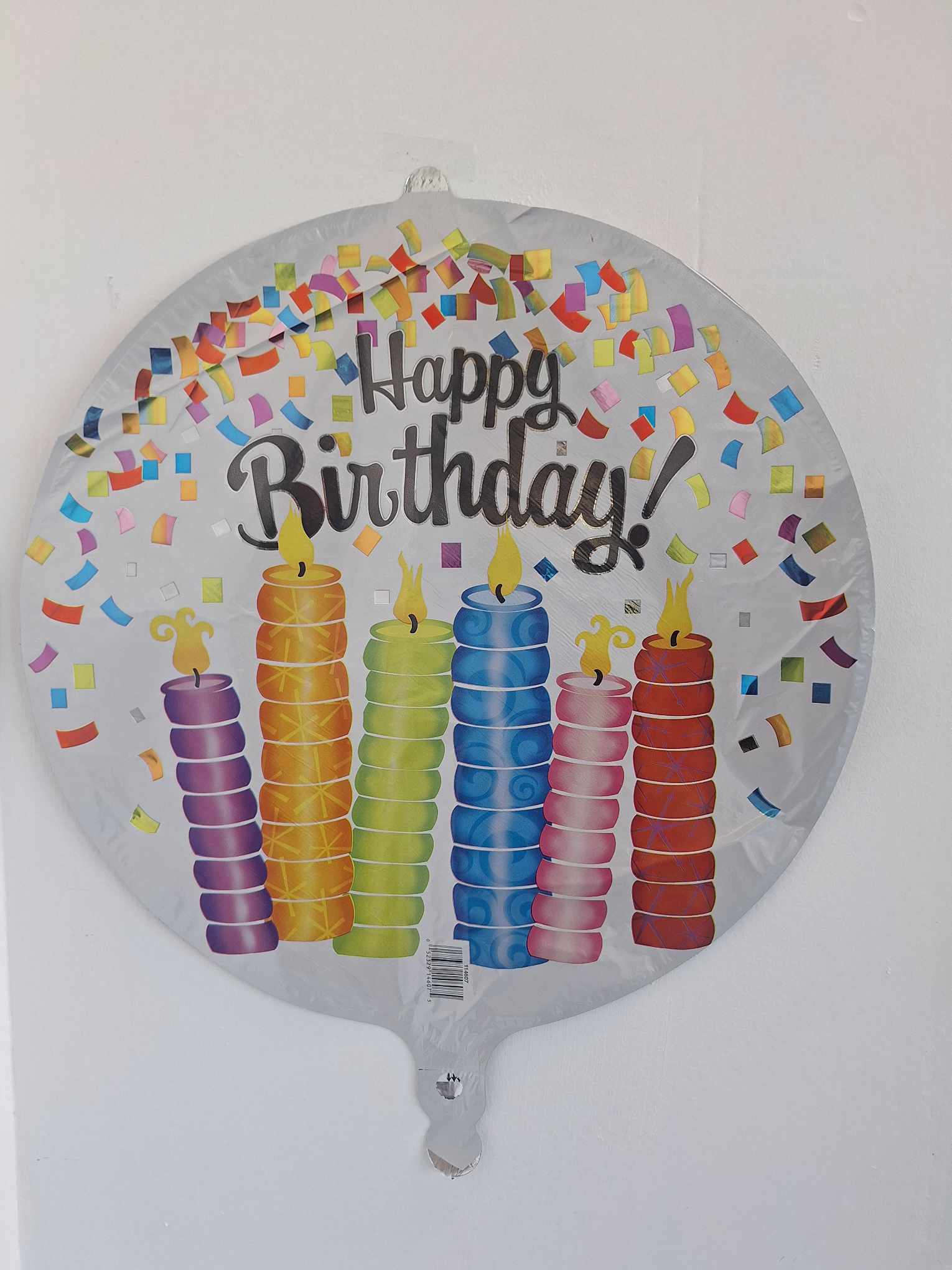 Round birthday balloon with colorful candles and confetti