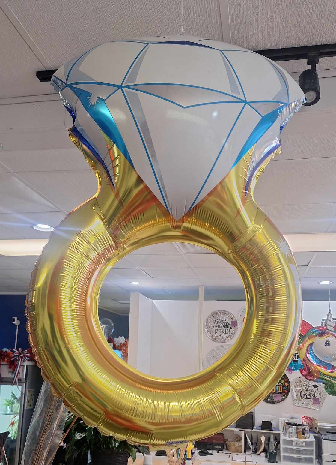 Large diamond ring-shaped foil balloon hanging indoors