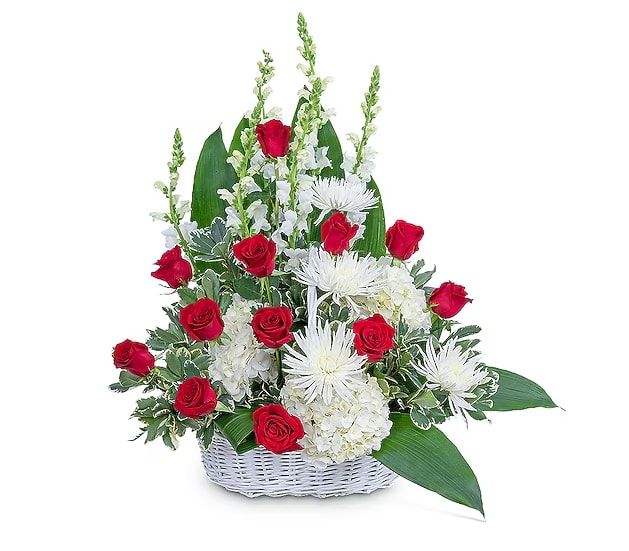 Red roses and white flowers in a white basket arrangement