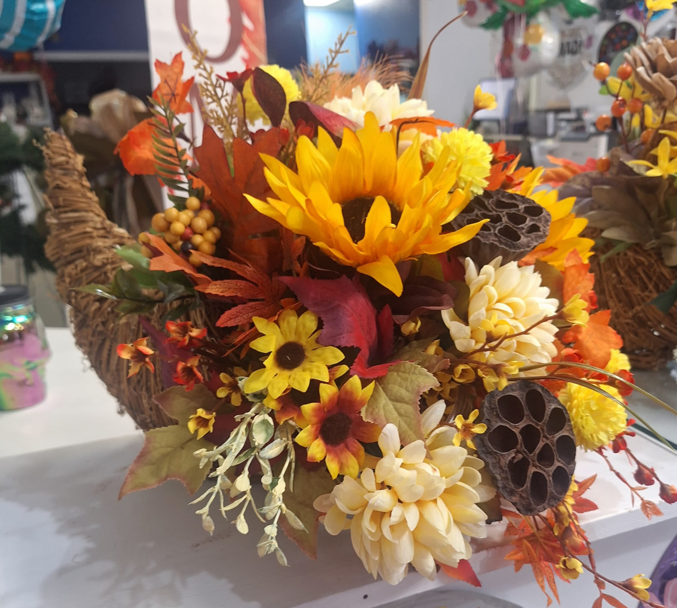 Autumn floral arrangement with sunflowers and cream mums in a woven basket