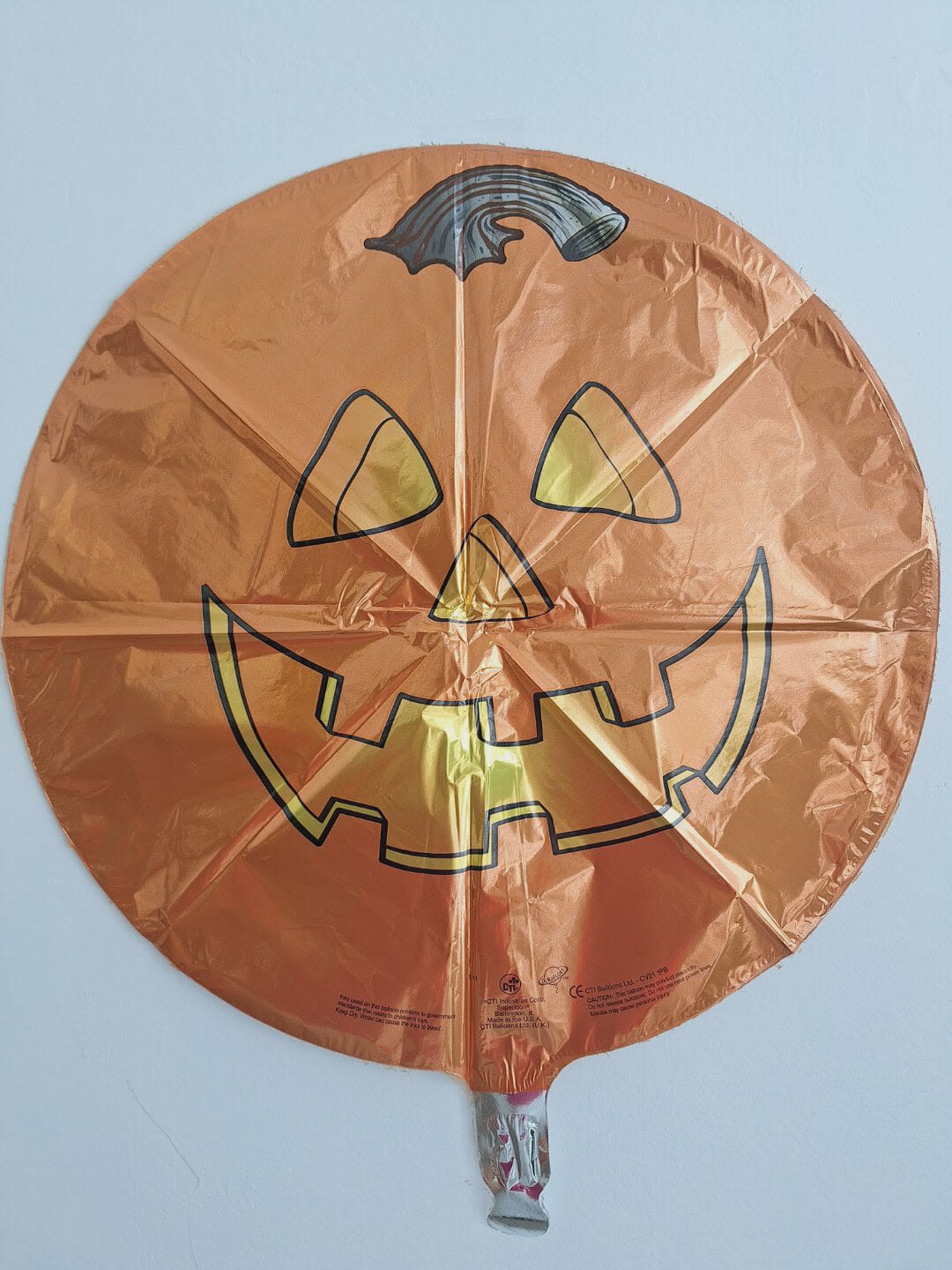 Orange jack-o'-lantern foil balloon on a white background