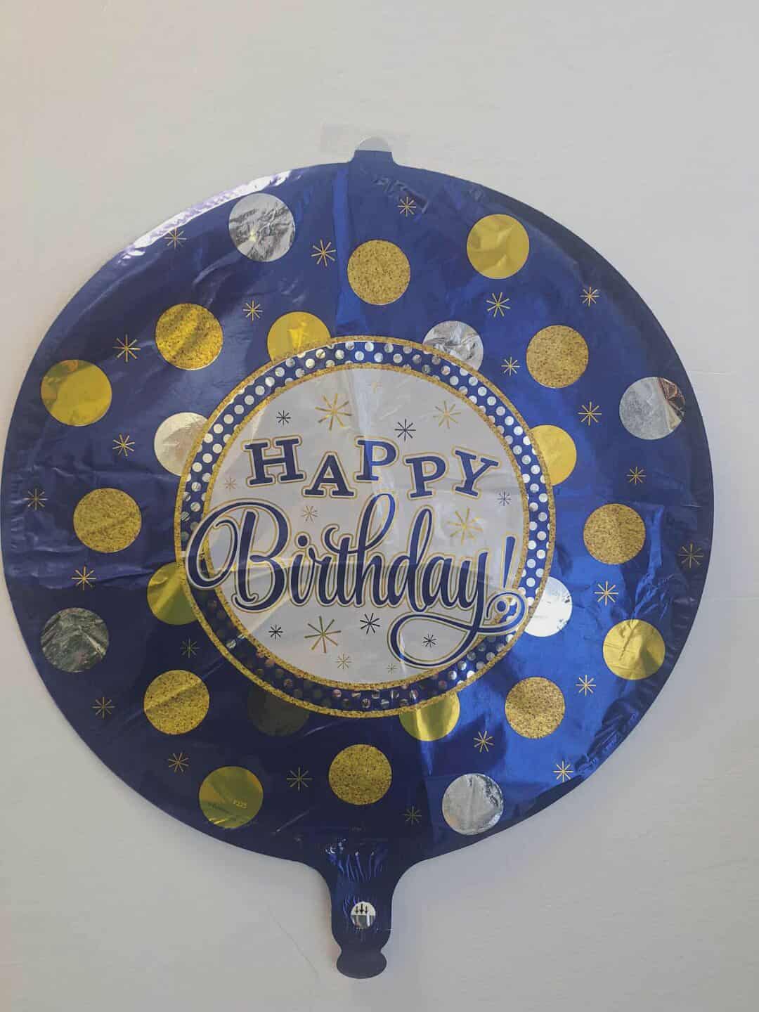 Round blue birthday balloon with gold and silver dots