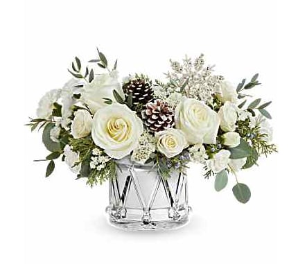 White roses and pinecones arranged in a clear glass vase