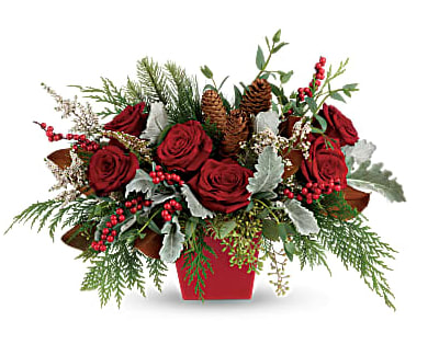 Red roses in a red container with pinecones and berries