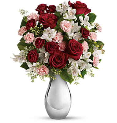 Red roses and pink carnations in a clear glass vase