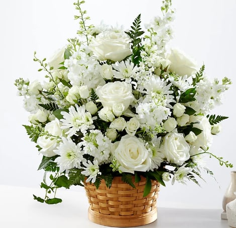 White roses and daisies arranged in a woven basket