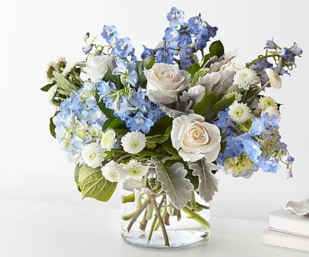 Blue and white flower arrangement in a clear glass vase