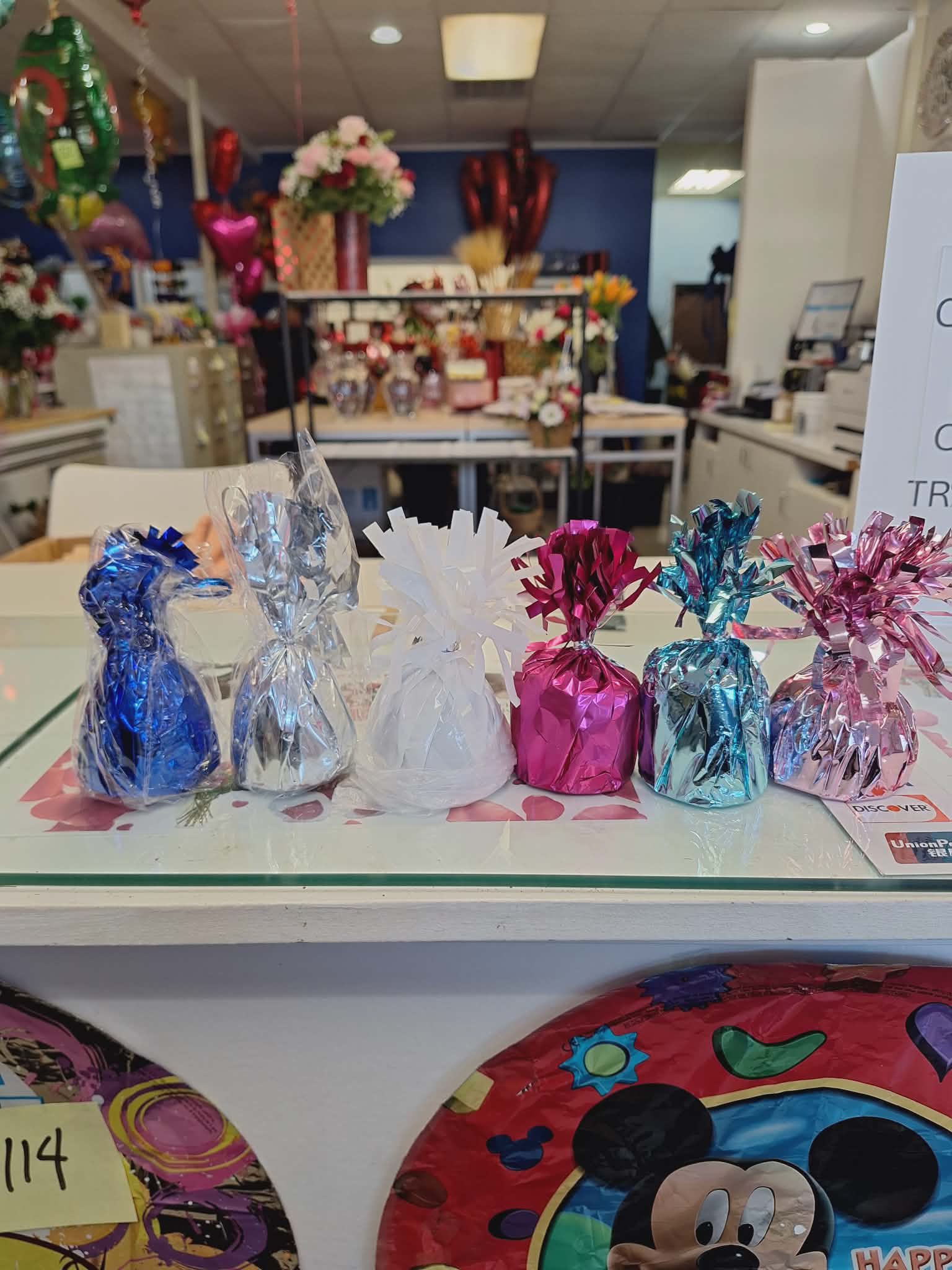 Foil-wrapped gift bags in blue, silver, white, pink, and teal on a counter